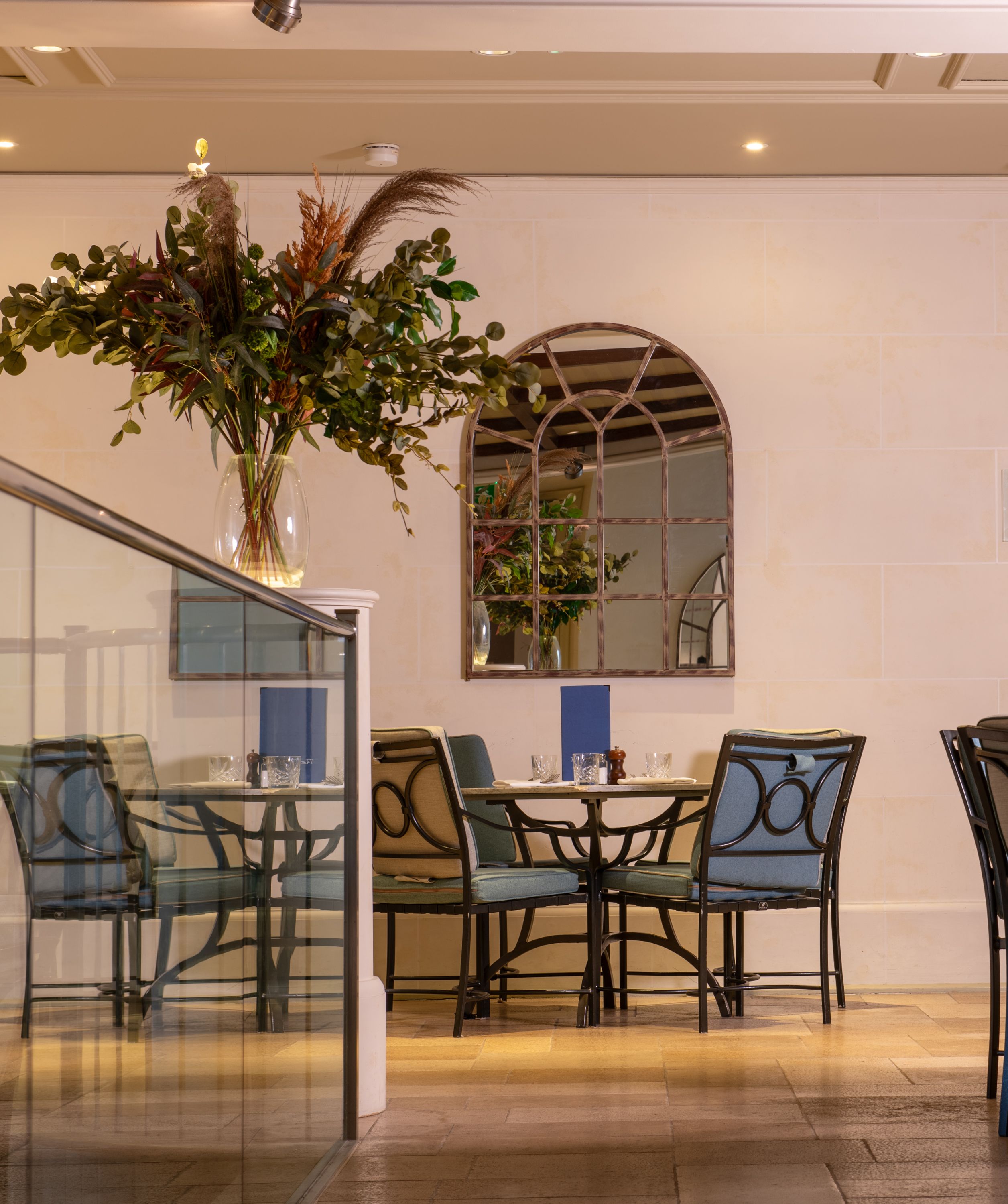a seating area in a hotel with a plant and mirror