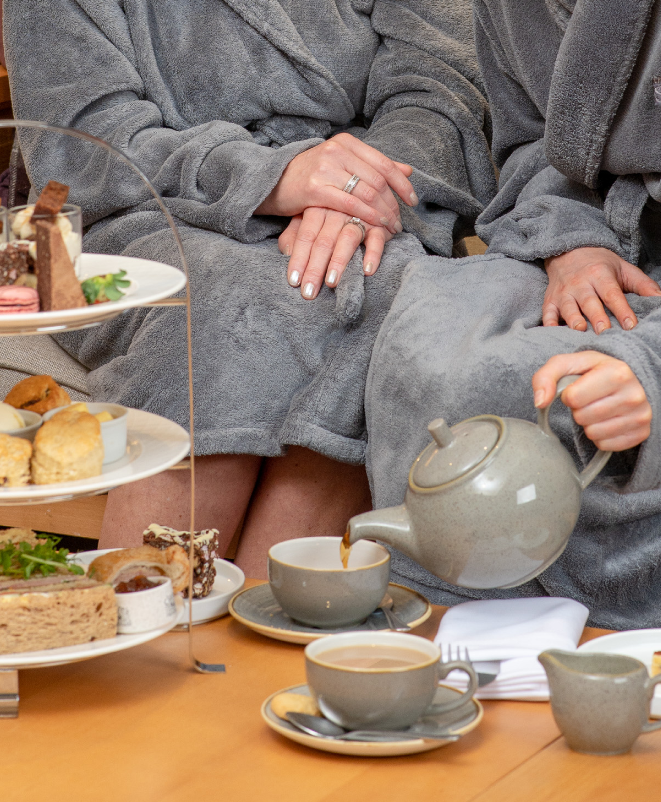 Women pouring tea whilst enjoying afternoon tea