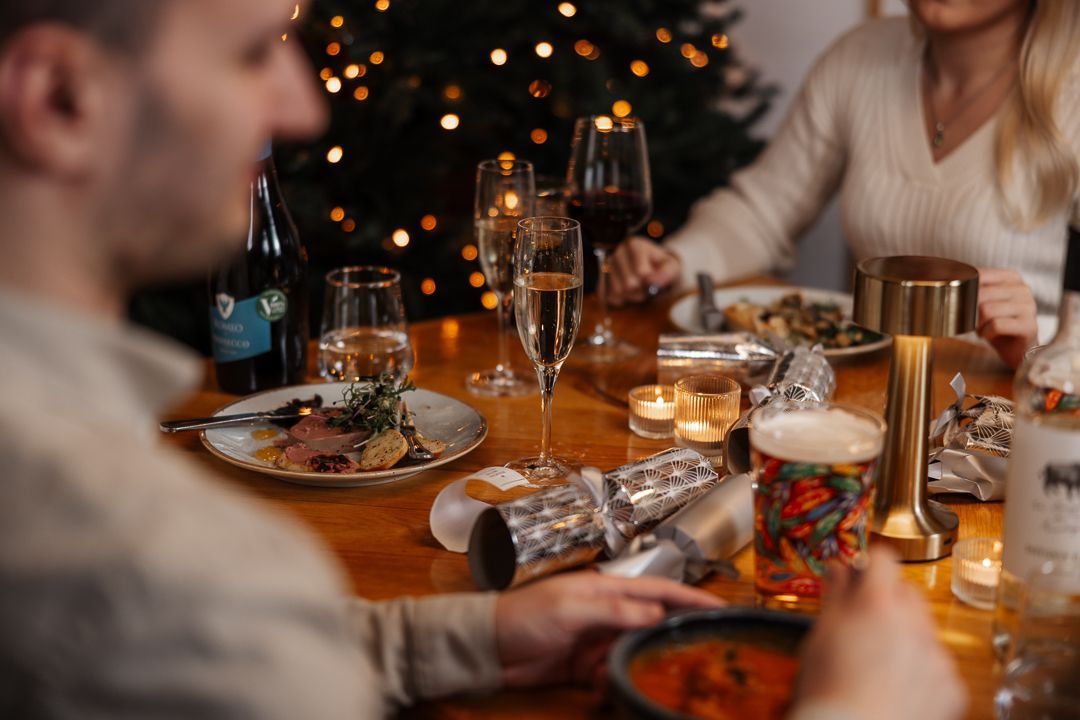 Christmas dining with food, drinks and crackers on table