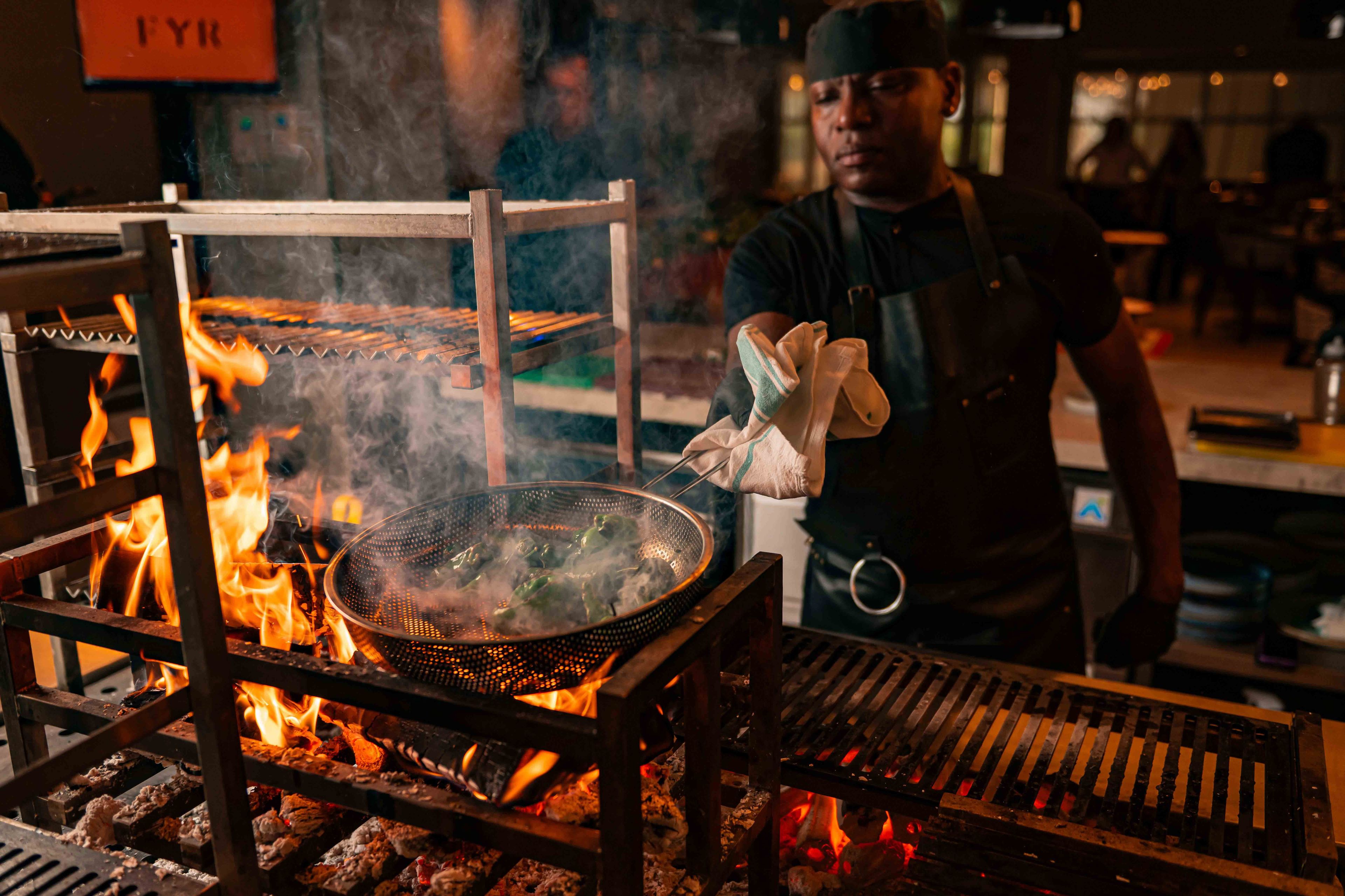 BBQ Padron peppers being charred directly over an FYR grill